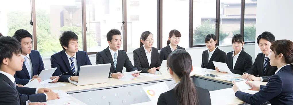 自治体の担当者が会議で資料を用いて説明し、庁内で共有している様子