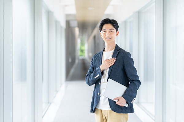 若いスタッフ（男性）が自信をもって会話しているイメージ